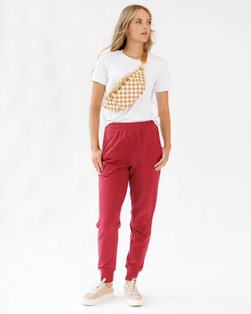 Model wearing a white shirt with red jogger sweatpants
