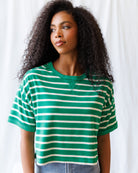 Woman wearing a green and white striped shirt against a plain background
