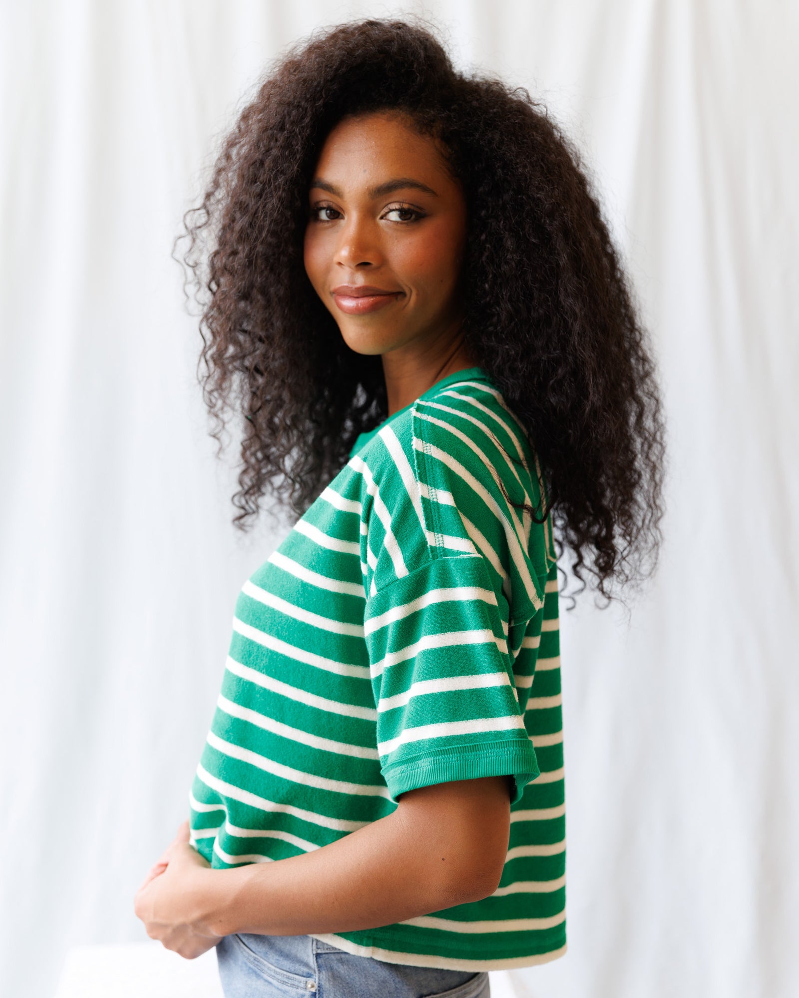 Woman wearing a green and white striped shirt against a white background