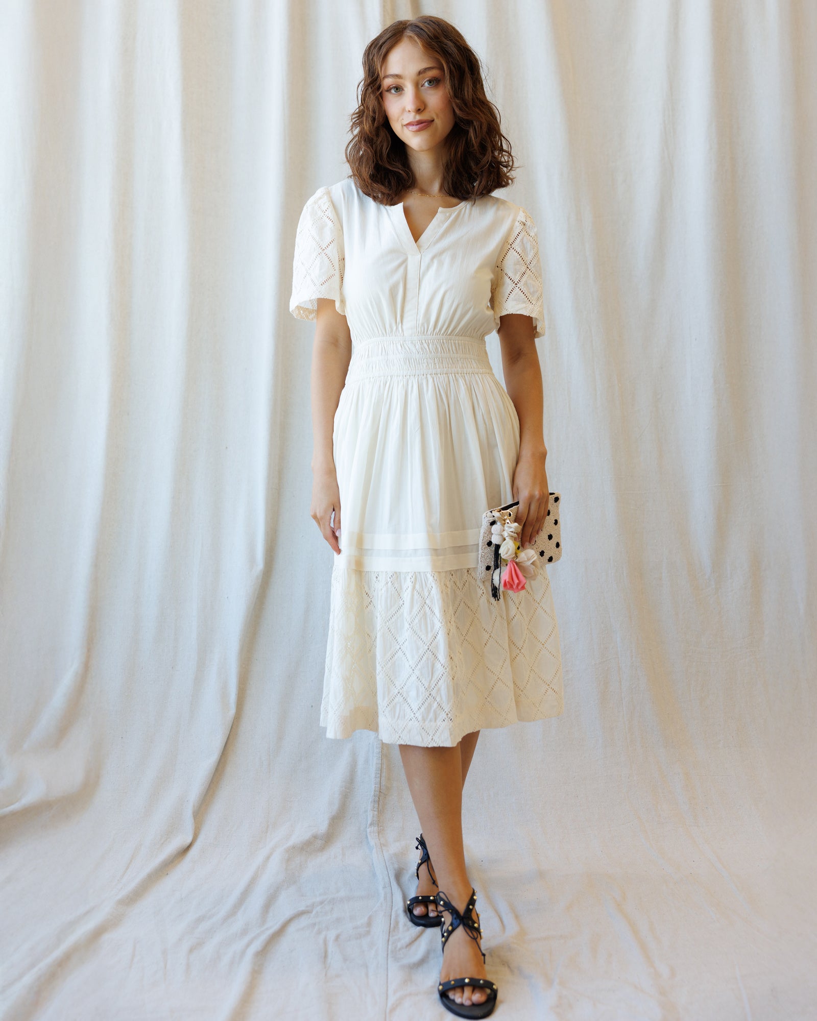 Woman wearing a white dress against a plain background