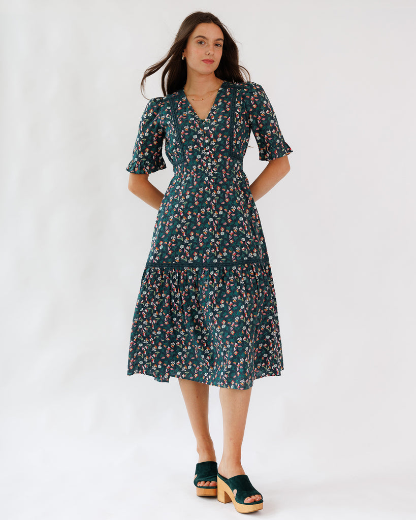 Model wearing a green/blue with pink floral printed half sleeve midi length dress