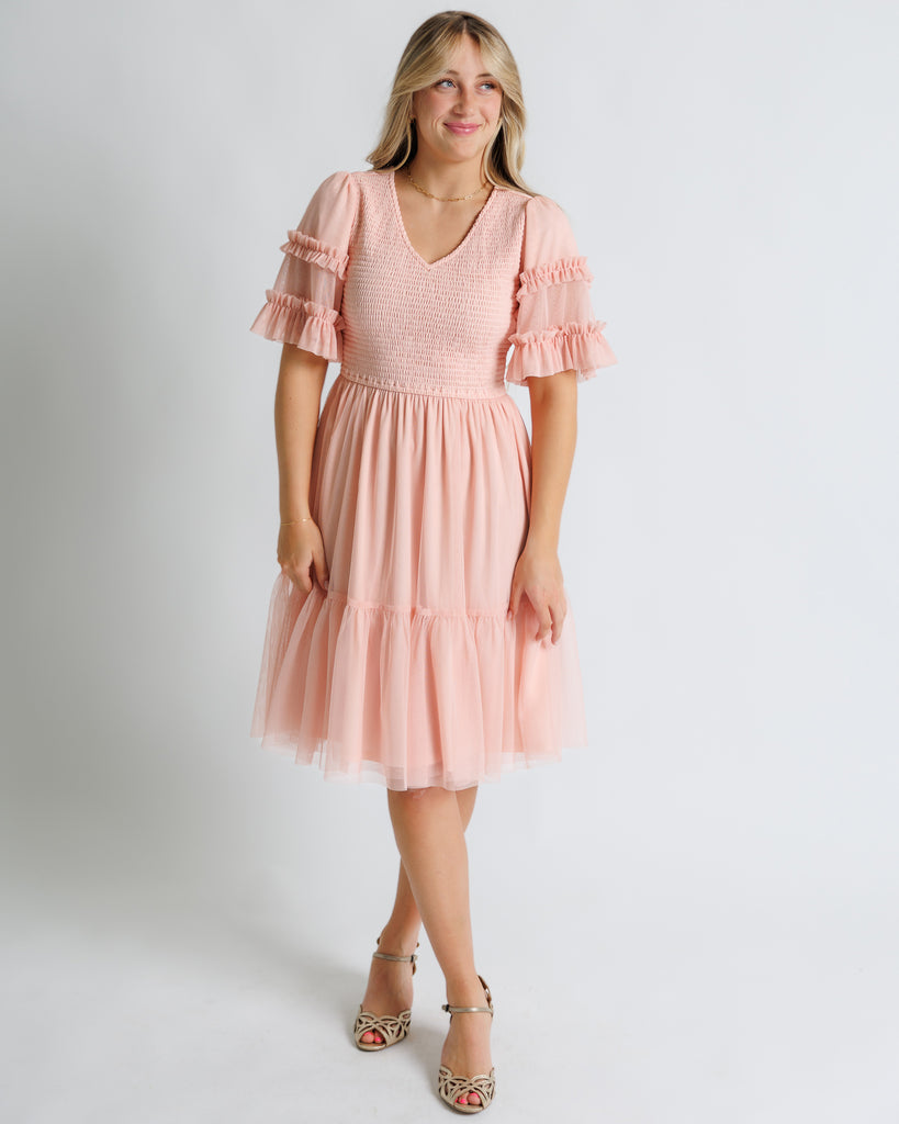 Model wearing a light pink short sleeve with ruffles, v-neck, midi tulle dress
