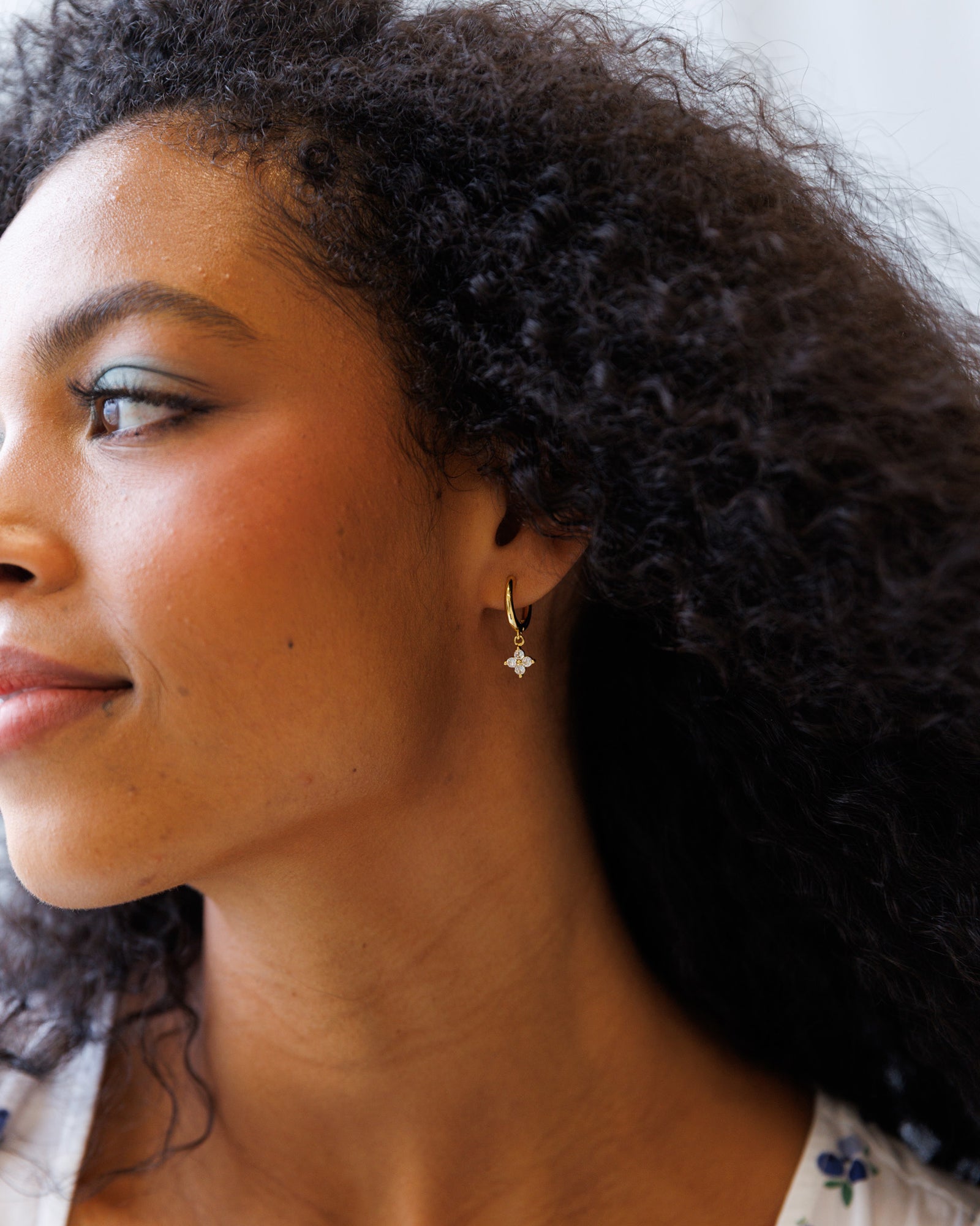 Close-up of a woman wearing a diamond earring with a blurred background
