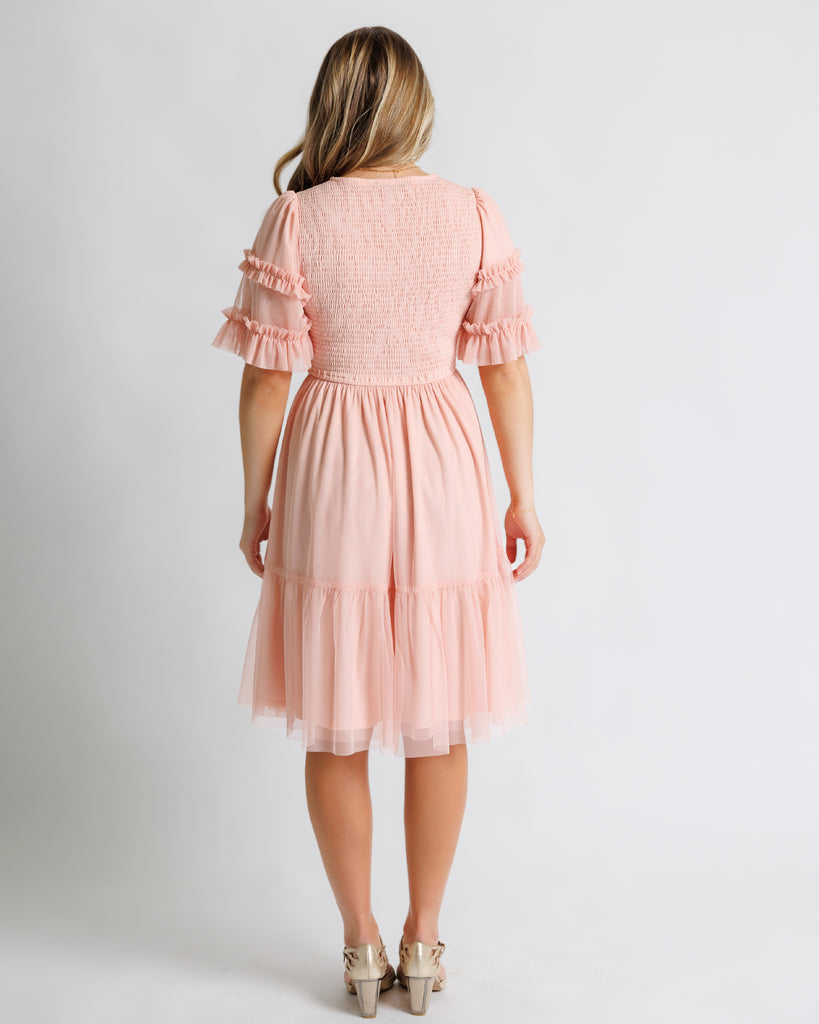 Model wearing a light pink short sleeve with ruffles, v-neck, midi tulle dress