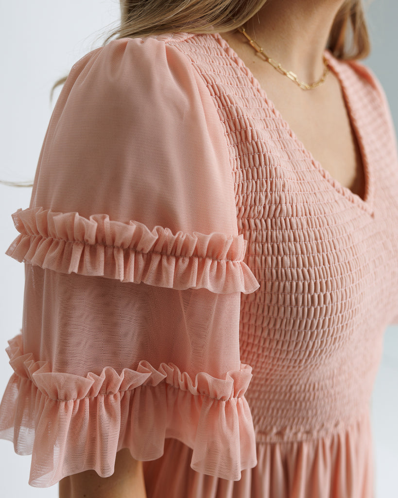 Model wearing a light pink short sleeve with ruffles, v-neck, midi tulle dress