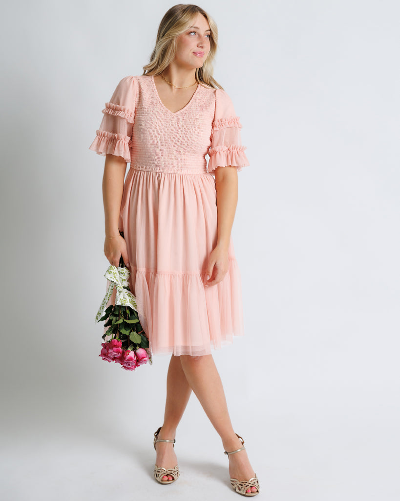 Model wearing a light pink short sleeve with ruffles, v-neck, midi tulle dress