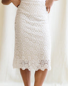 White lace skirt worn by a person on a white background