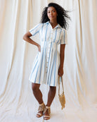 Woman wearing a striped dress against a plain background