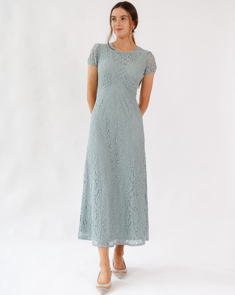 Woman wearing a light blue lace dress on a white background