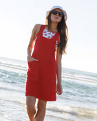 Woman in a red dress with floral pattern on a beach