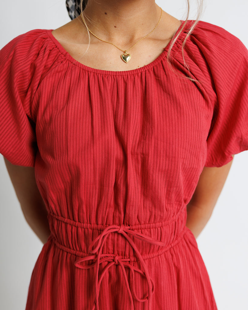 Model wearing a red short puffed sleeve scoop neck midi dress.