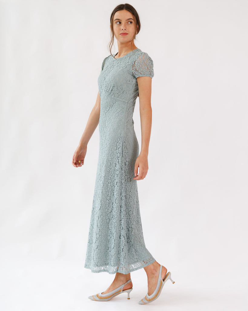 Woman wearing a light blue lace dress on a white background
