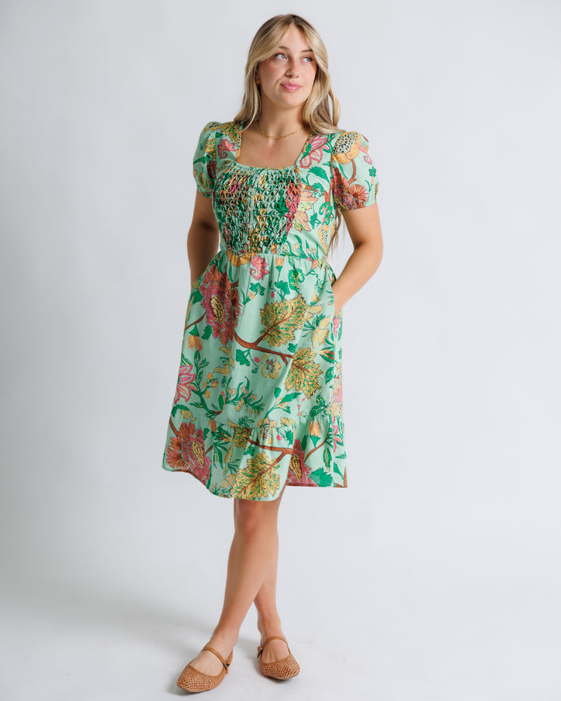 Model wearing a green floral print short sleeve, square neck, knee length dress.