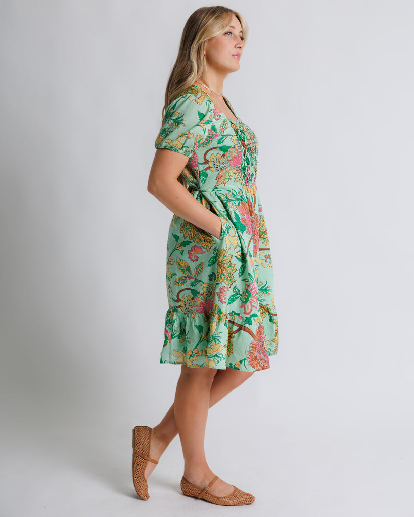 Model wearing a green floral print short sleeve, square neck, knee length dress.