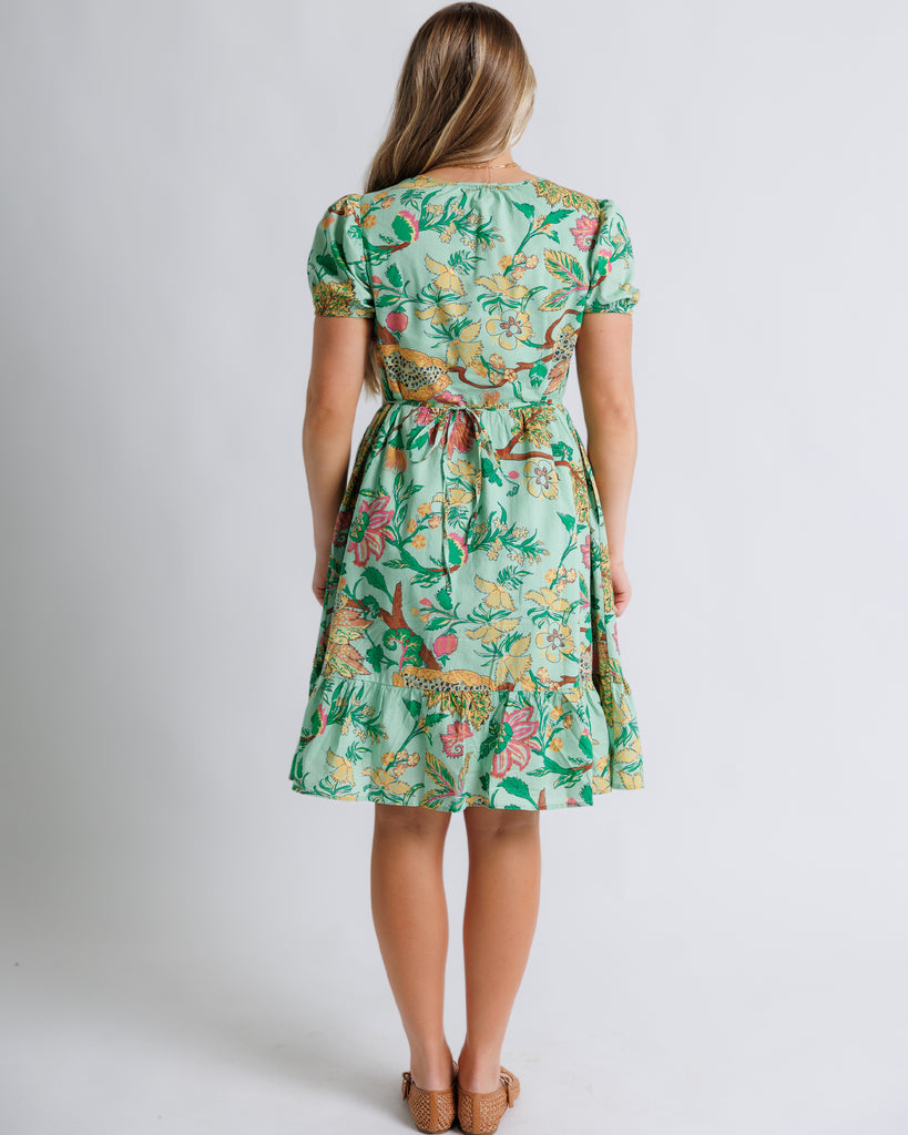 Model wearing a green floral print short sleeve, square neck, knee length dress.
