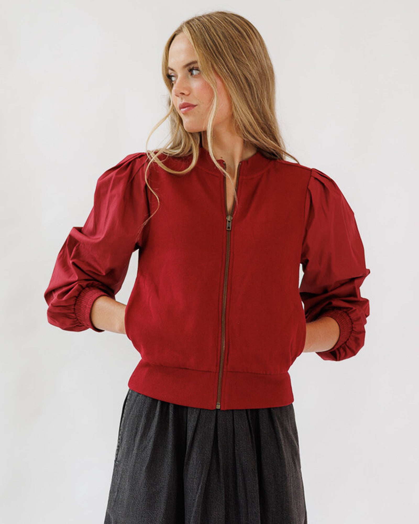 Woman wearing a red jacket with puffed sleeves on a white background
