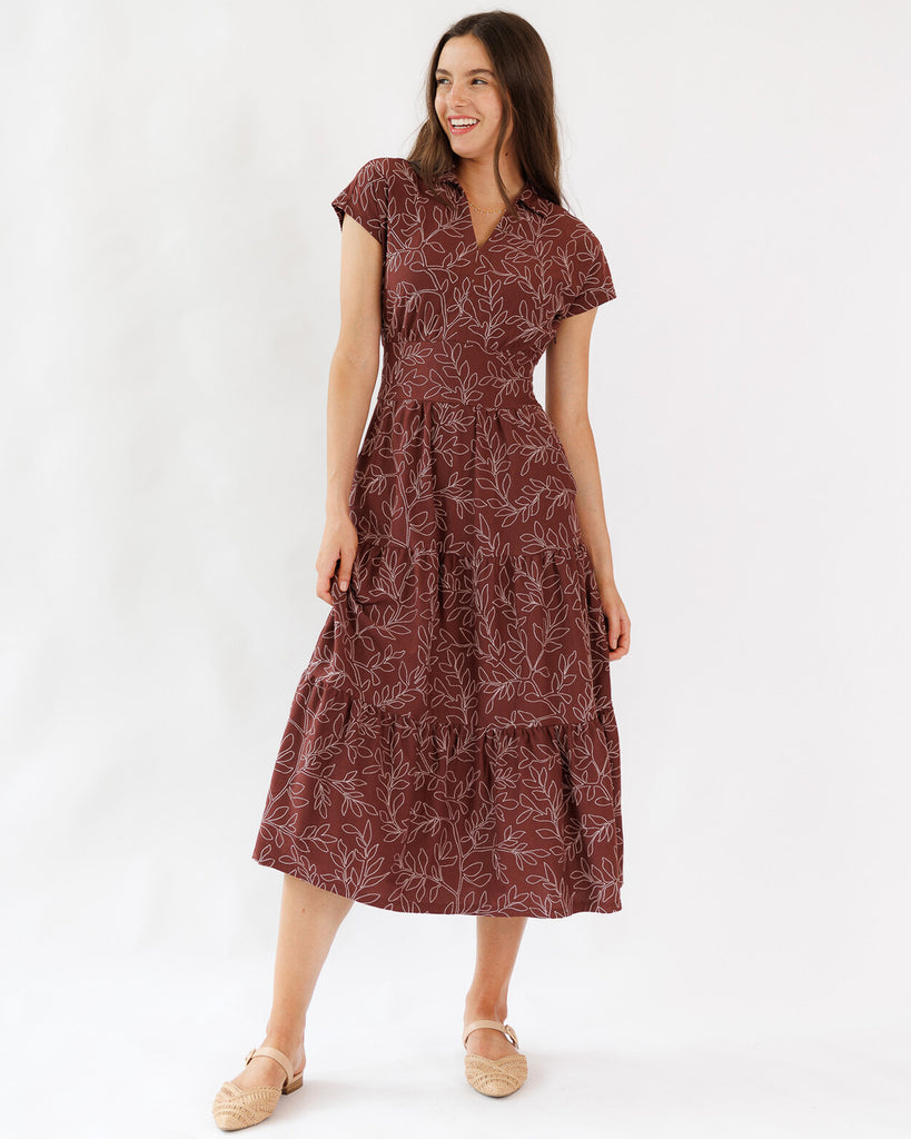 Woman wearing a maroon dress with a subtle pattern on a white background