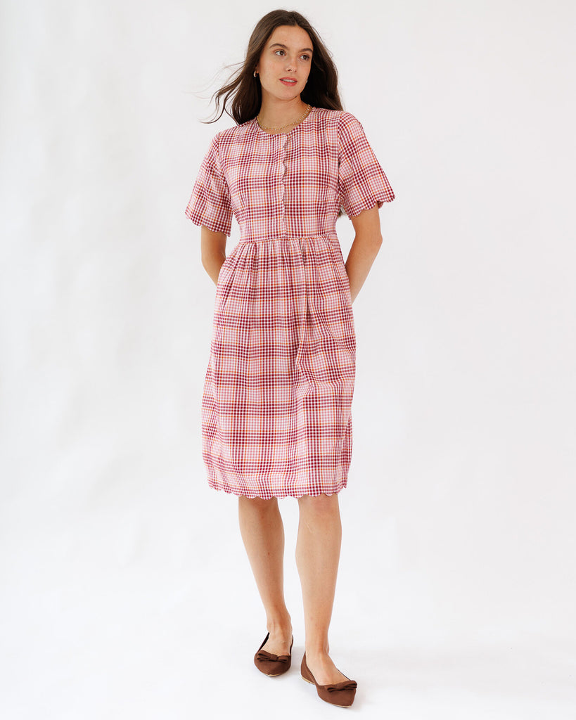 Woman wearing a red and white checkered dress on a white background