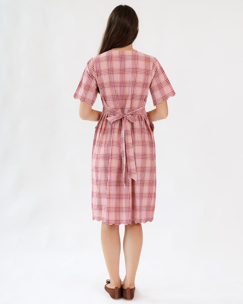 Woman wearing a red and white checkered dress on a white background
