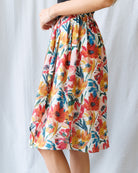 Colorful floral skirt worn by a person on a white background