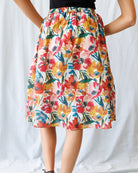 Colorful floral skirt worn by a person on a white background