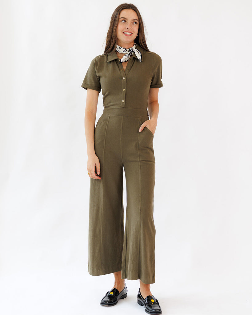 Woman wearing a green jumpsuit with a white background
