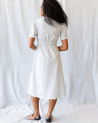 Woman wearing a light blue dress standing against a plain white background