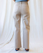 Beige pants worn by a person on a white background
