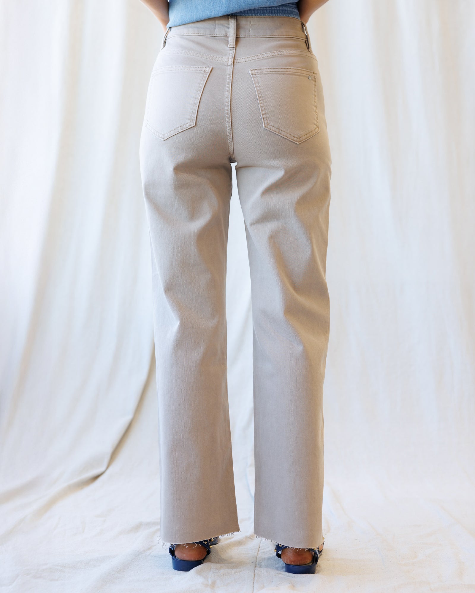 Beige pants worn by a person on a white background