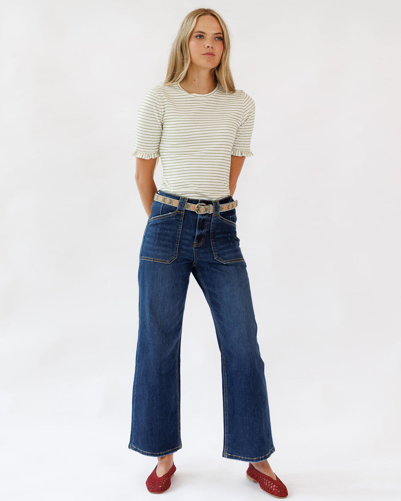 Woman wearing a striped shirt and blue jeans on a white background