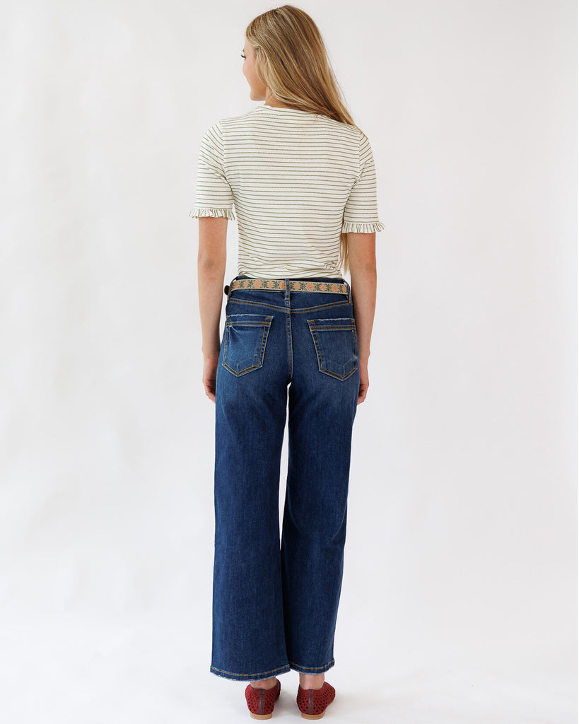 Woman wearing a striped shirt and blue jeans on a white background