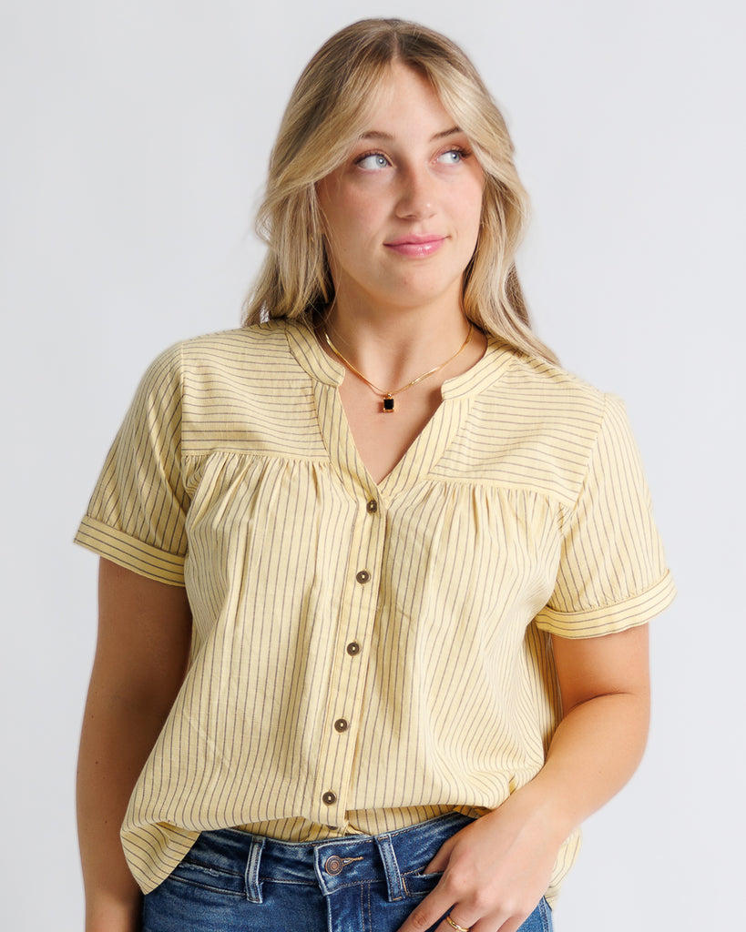 Model wearing yellow with stripes short sleeve v-neck blouse