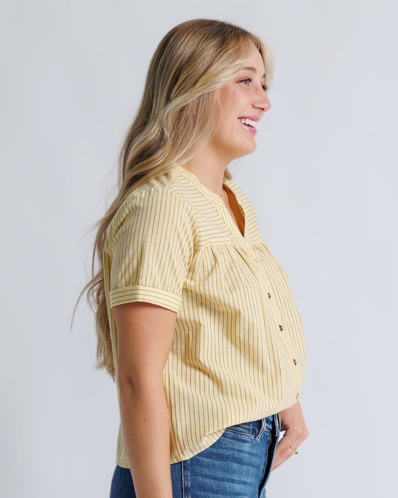 Model wearing yellow with stripes short sleeve v-neck blouse