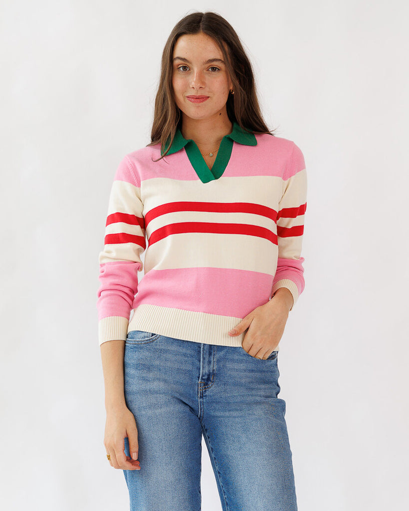 Woman wearing a colorful striped sweater with a green collar on a white background