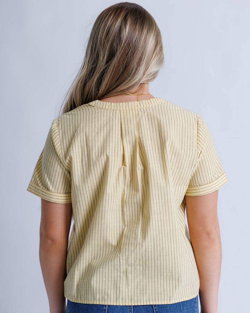 Model wearing yellow with stripes short sleeve v-neck blouse