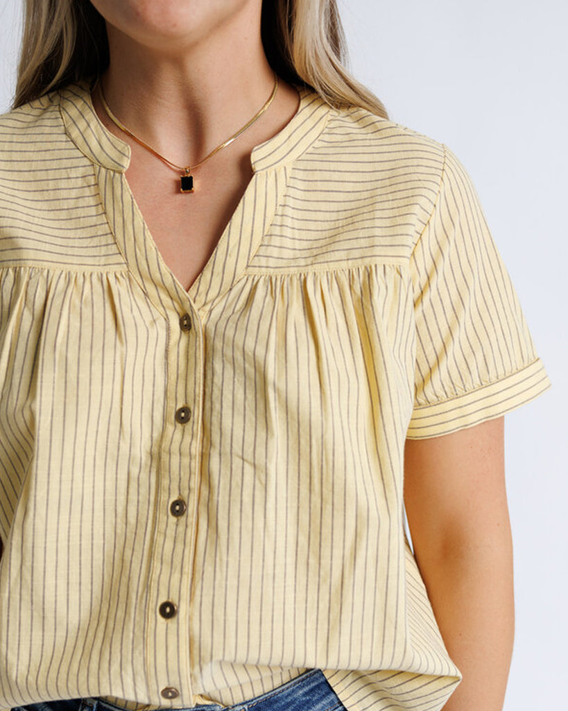 Model wearing yellow with stripes short sleeve v-neck blouse