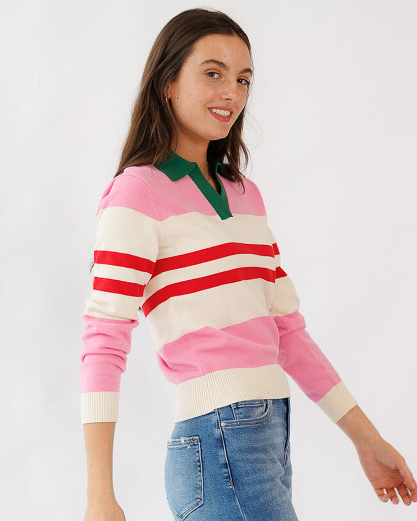 Woman wearing a colorful striped sweater with a plain background