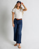 Model wearing dark blue wide leg denim jeans.