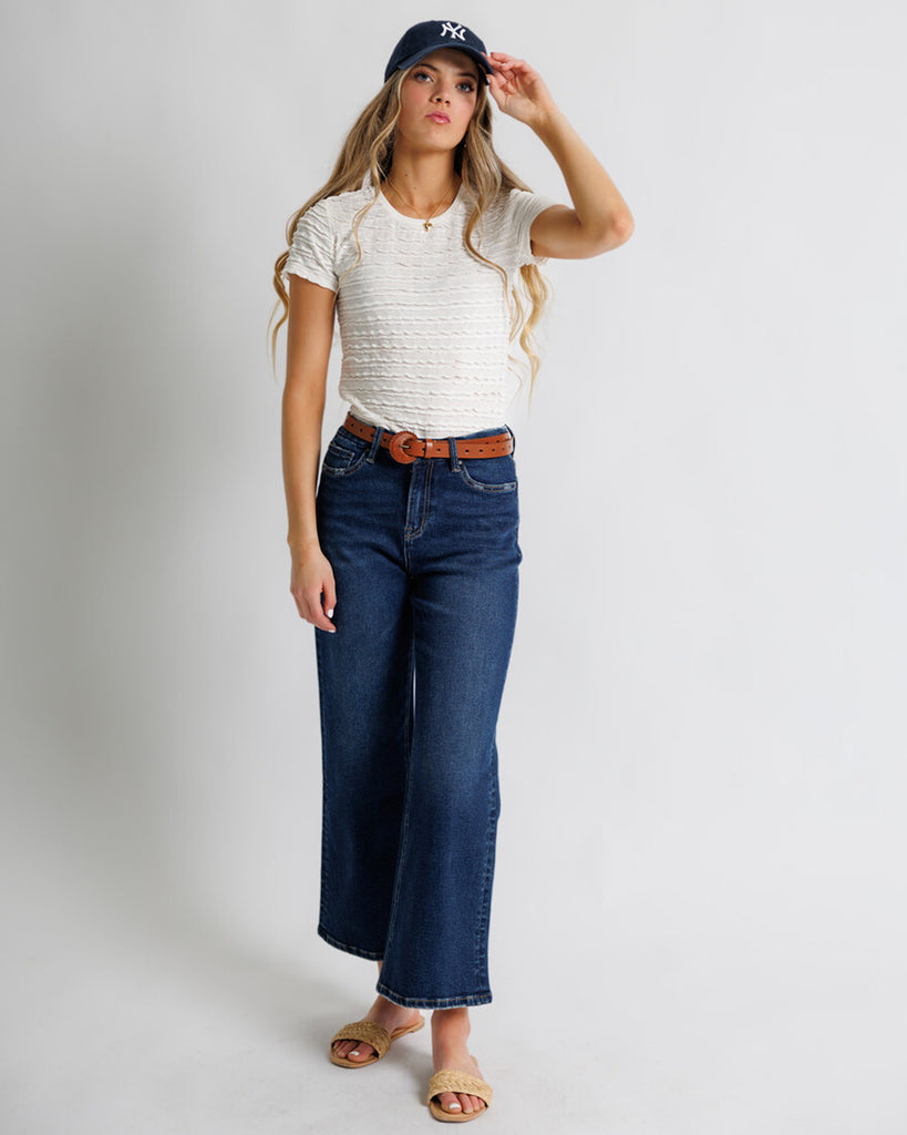 Model wearing dark blue wide leg denim jeans.