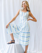 Woman wearing a blue and white striped dress against a white background