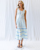 Woman wearing a blue and white striped dress against a white background