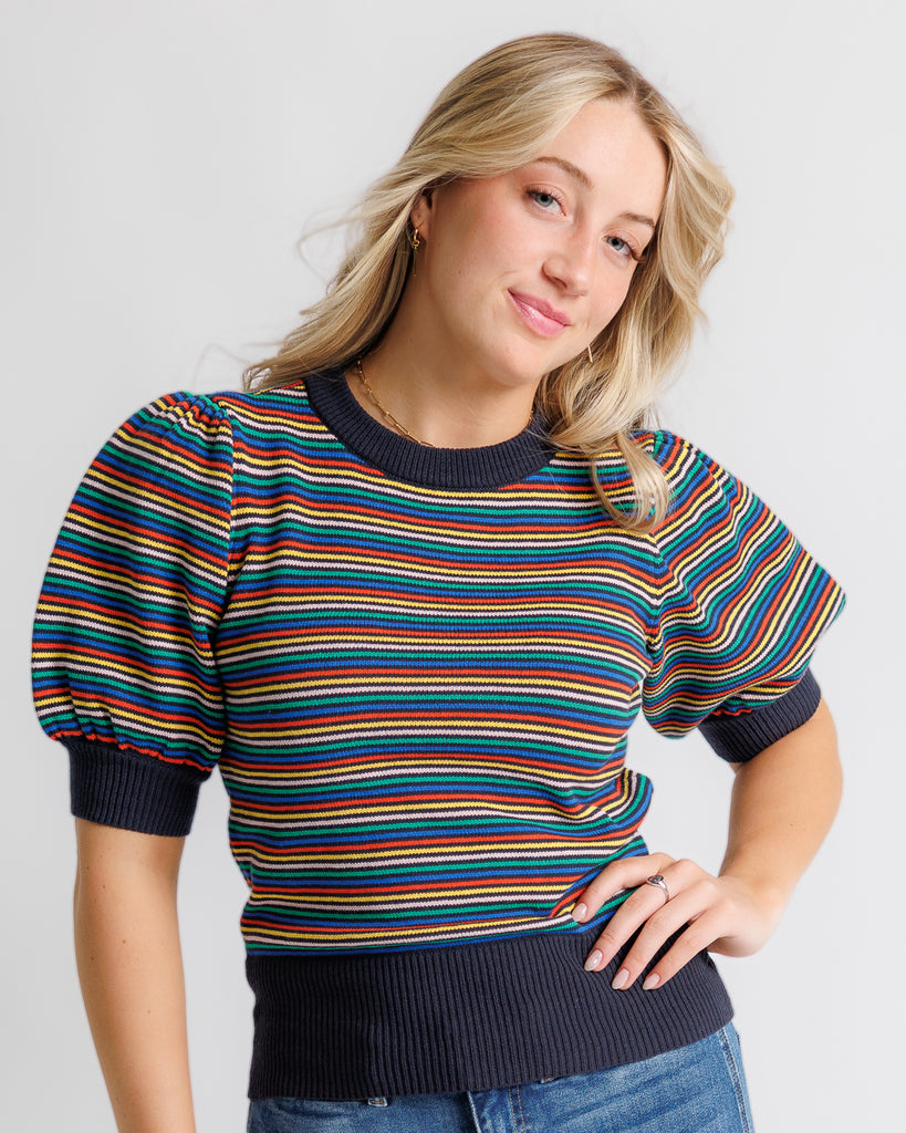 Model wearing a black with bright stripes short puffed sleeve crew neck pullover.