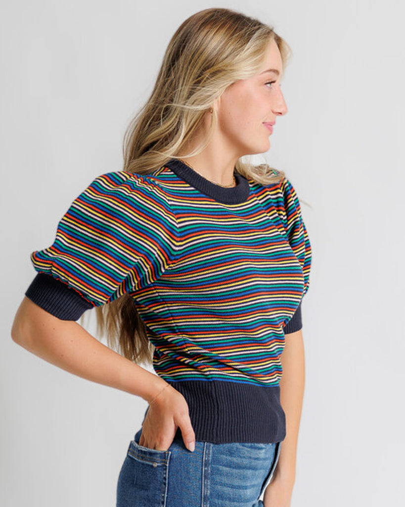 Model wearing a black with bright stripes short puffed sleeve crew neck pullover.