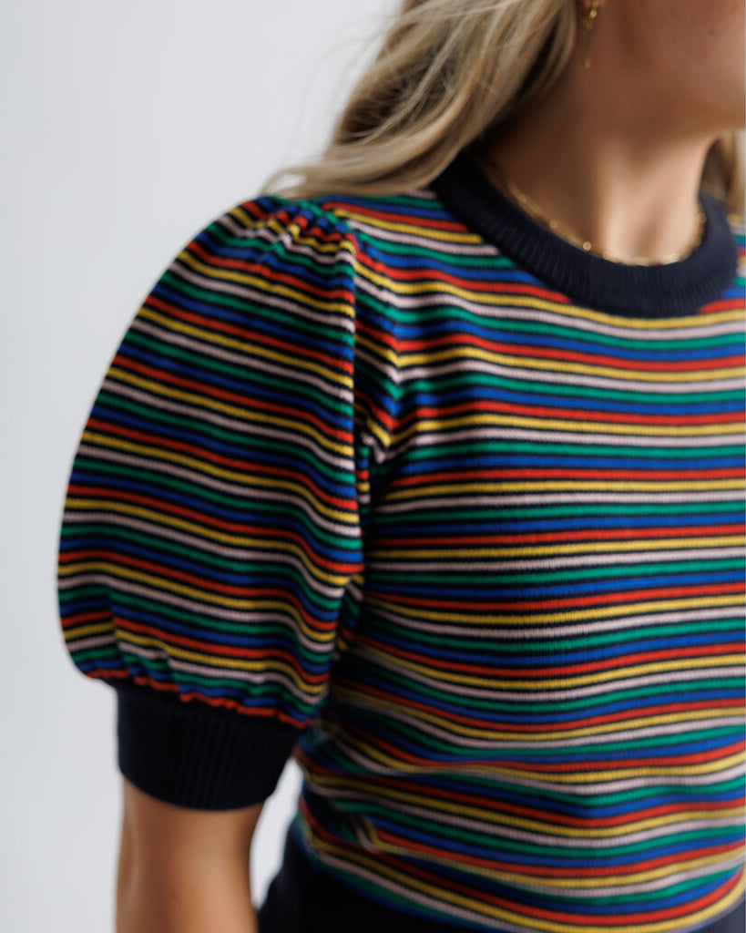 Model wearing a black with bright stripes short puffed sleeve crew neck pullover.