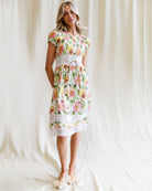 Woman wearing a floral dress against a plain background