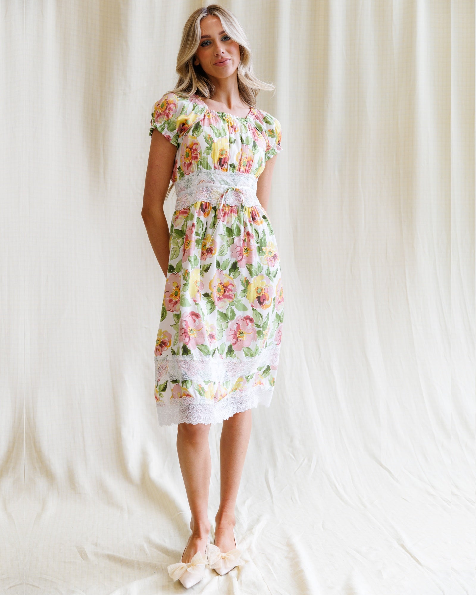Woman wearing a floral dress against a plain background