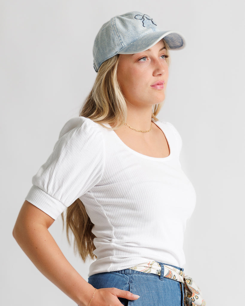 Model wearing a white short sleeve, scoop neck, ribbed tee