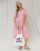 Image of a woman wearing a red and white striped dress on a canvas background