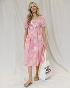 Image of a woman wearing a red and white striped midi length dress on a canvas background