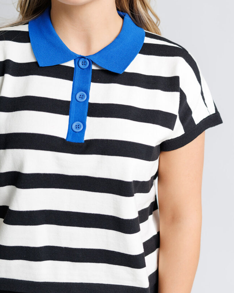 Model wearing a black and white striped short sleeve polo with a blue collar